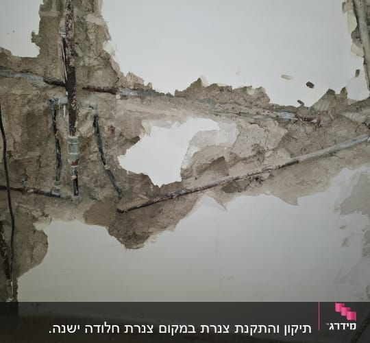 צנרת חשופה בקיר עם טיח מתקלף